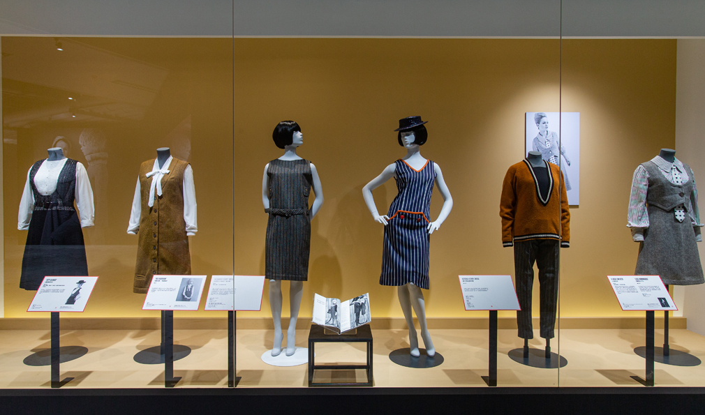 1960-63 翻轉男裝     瑪莉官將原本拿來製作紳士西裝或軍裝的剪裁面料，誇大演繹成輕鬆有趣的女裝。 的圖說